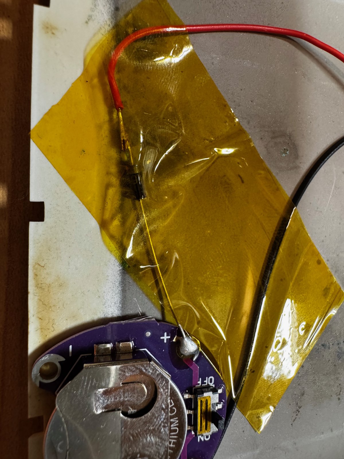 A coin cell holder with the diode, insulated with Kapton tape A coin cell holder with the diode, insulated with Kapton tape